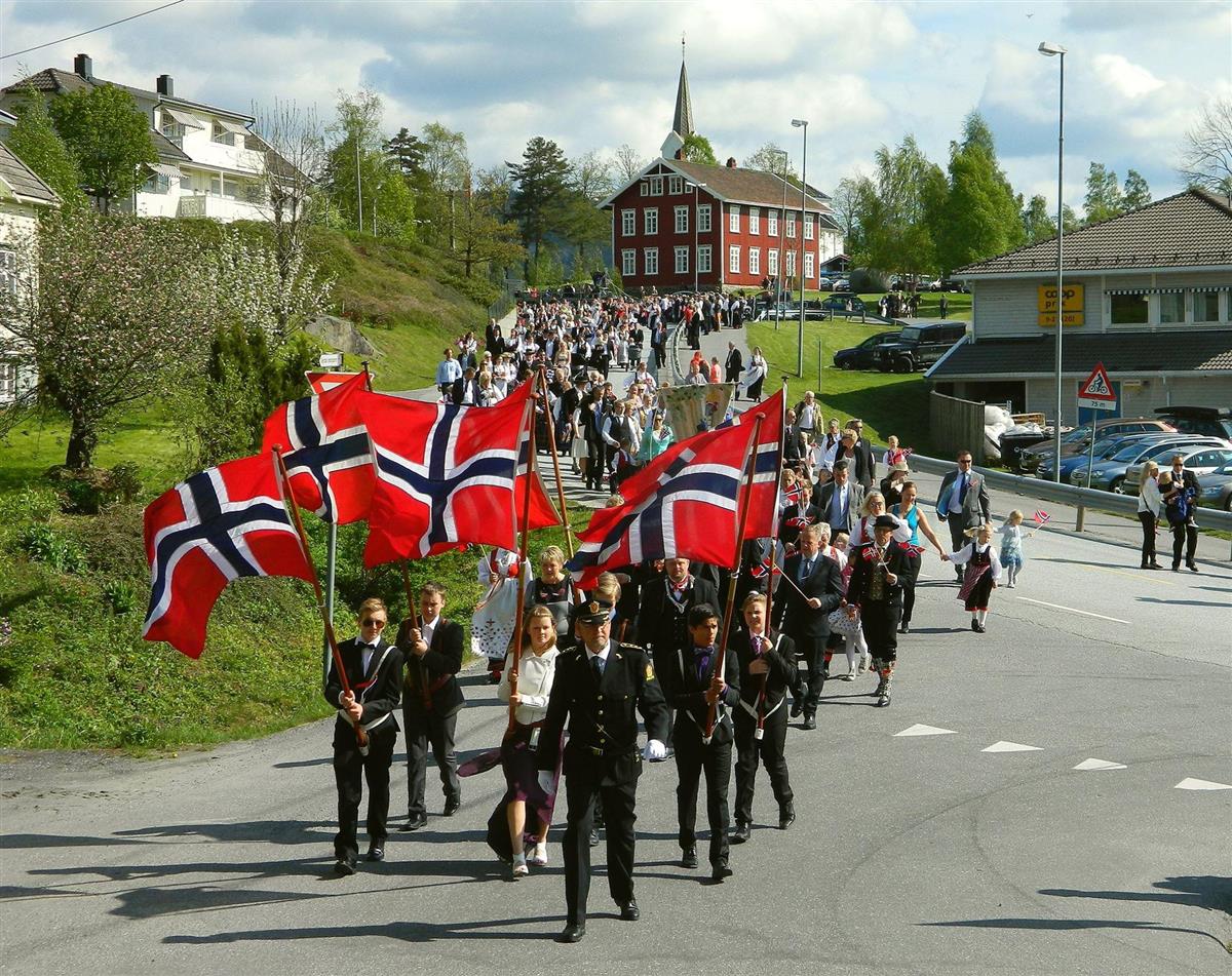 Bilde av 17. mai tog. Bakgrunn er Almuestaua og Gjerstad kirke. - Klikk for stort bilde